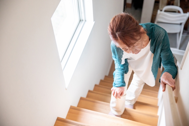 階段を上っていて膝が痛い女性