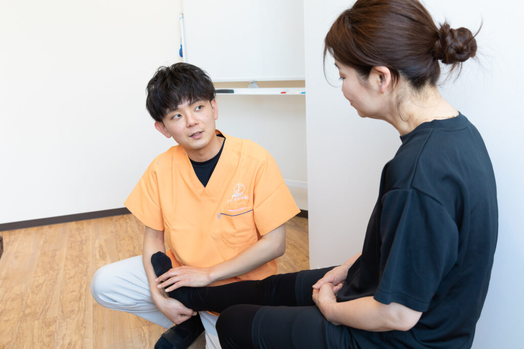 よろずや接骨院のスタッフが笑顔で治療をしている様子