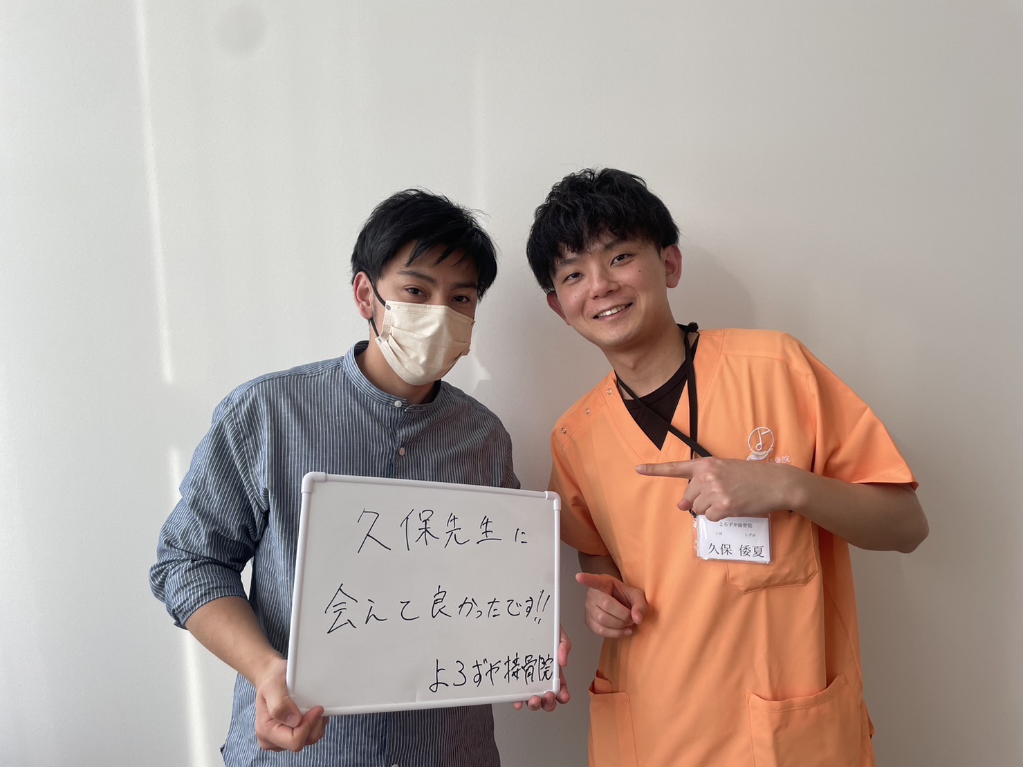 膝の痛みがつらくてよろずや接骨院に通院していたが、症状が改善して卒業する際に整骨院のスタッフと写真を撮る男性